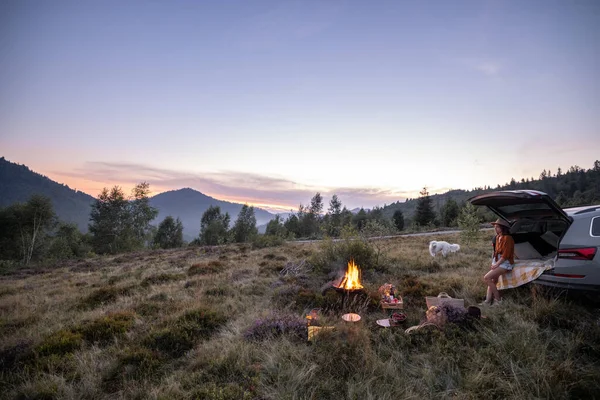 Wanita bepergian dengan mobil dan memiliki piknik di pegunungan — Stok Foto