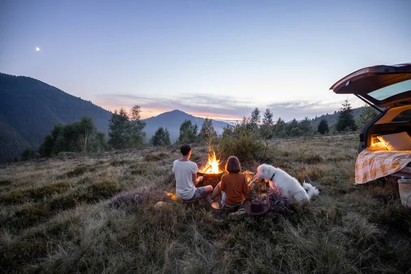 Пара біля вогню на пікніку в горах — стокове фото