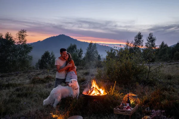 Coppia vicino al fuoco al picnic in montagna — Foto Stock