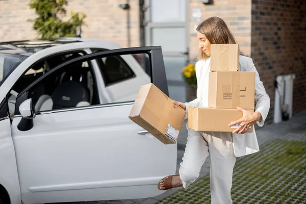 Frau mit Paketen in der Nähe ihres Autos und Hauses — Stockfoto