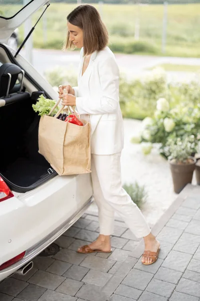 Frau liefert Lebensmittel mit Auto nach Hause — Stockfoto