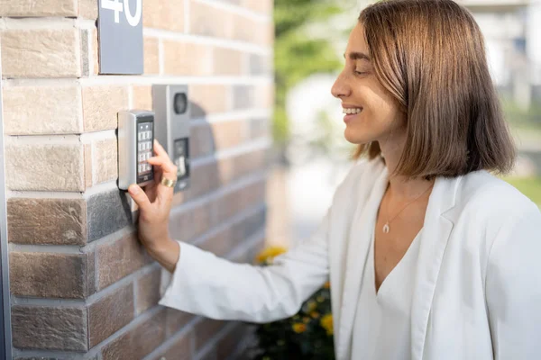 Mujer ingresando código en un teclado para acceder a una puerta — Foto de Stock