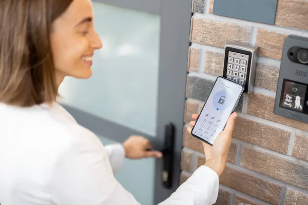 Öppningsdörr med smart telefon och tangentbord på väggen — Stockfoto