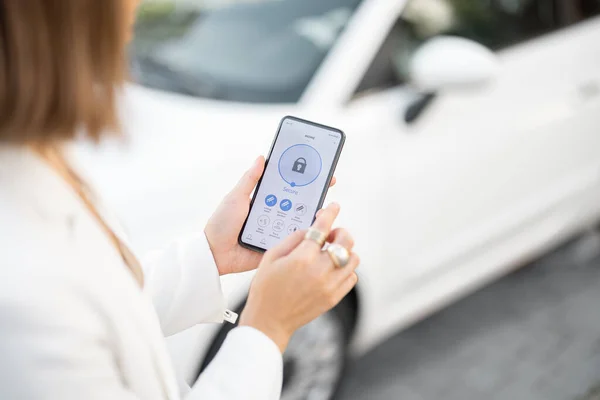 Mujer alarma de coche de control con teléfono móvil — Foto de Stock