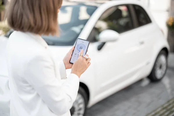 Žena ovládání auto alarm s mobilním telefonem — Stock fotografie