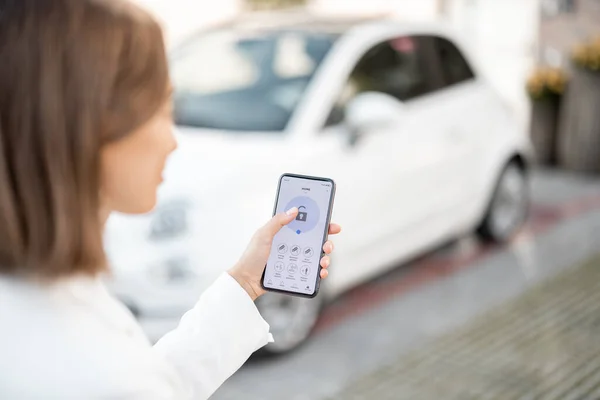 Frau steuert Auto-Alarm mit Handy — Stockfoto
