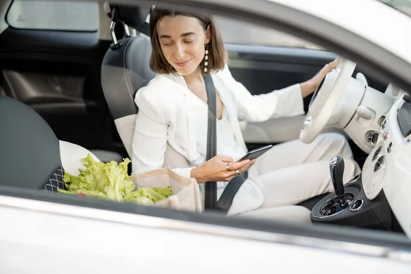 Žena řízení auto s nákupní taškou plnou potravin — Stock fotografie