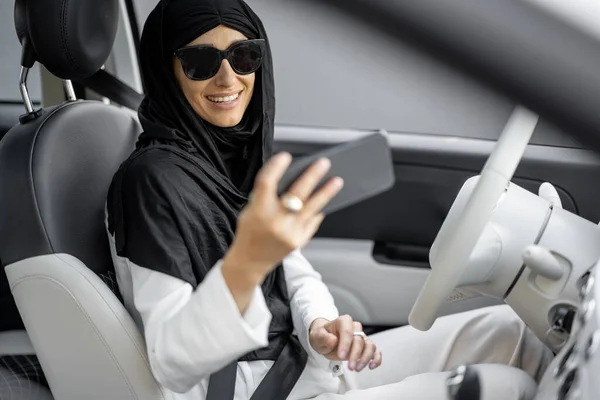 Muslimka mluví po telefonu při řízení auta — Stock fotografie