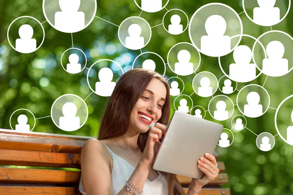 Young woman with digital tablet in the park — Stock Photo, Image