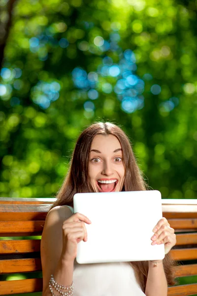 Jeune femme avec tablette numérique dans le parc — Photo