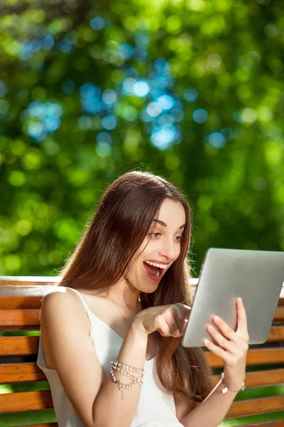 Молодая женщина с цифровым планшетом в парке — стоковое фото