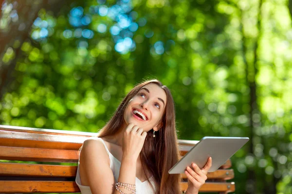 Mujer joven con tableta digital en el parque —  Fotos de Stock