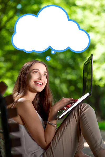 Jeune femme avec ordinateur portable dans le parc — Photo