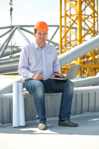 A foreman with drawings speaking phone at the construction. — Stock Photo, Image