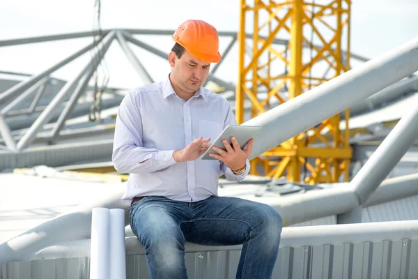 A foreman with digital tablet at the construction supervising the project. — Stock Photo, Image