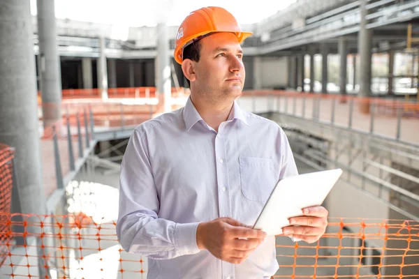 Un capataz con tableta digital que supervisa el proyecto en la construcción . — Foto de Stock