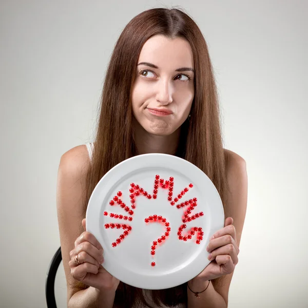 Young woman showing plate with vitamins — Stock Photo, Image
