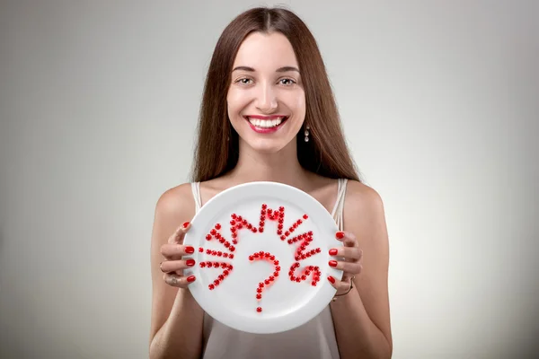 Young woman showing plate with vitamins — Stock Photo, Image