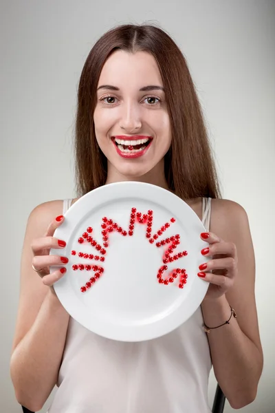 Junge Frau zeigt Teller mit Vitaminen — Stockfoto