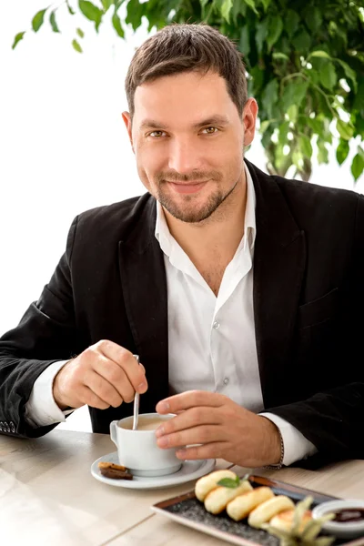 Handsome man drinking coffee at the restaurant — Stock Photo, Image