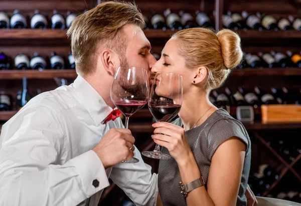 ロマンチックなワインの試飲、セラーを持っているカップル ストック写真