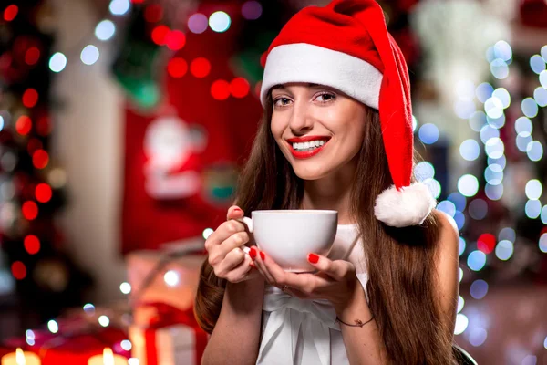 Jonge vrouw met een koffiekopje op Kerstmis — Stockfoto