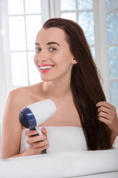 Woman drying hair with hairdryer — Stock Photo, Image