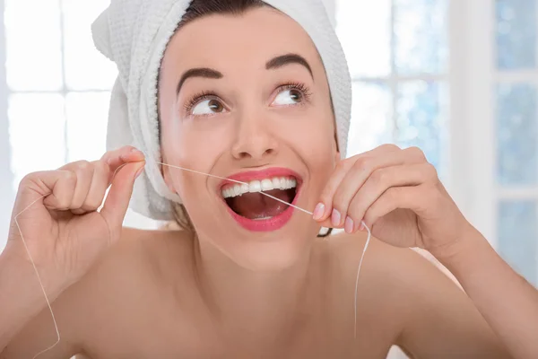 Mujer limpiando dientes con hilo dental —  Fotos de Stock