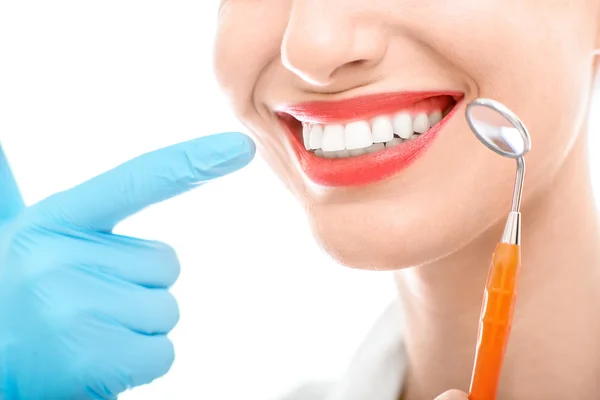 Kvinna med dental spegel på vit bakgrund — Stockfoto
