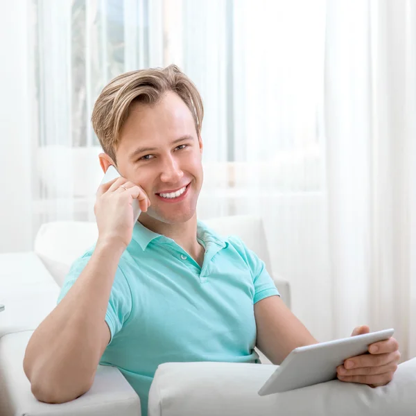 Man with gadget sitting at home — Stock Photo, Image