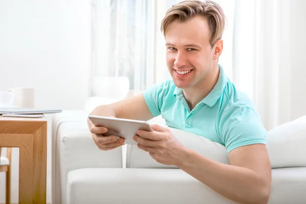 Homme avec gadget assis à la maison — Photo