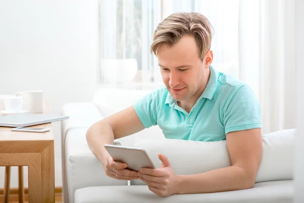 Man with gadget sitting at home — Stock Photo, Image