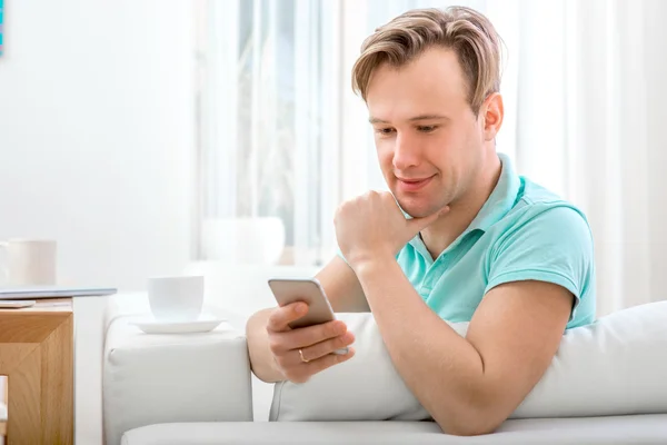 Homem com gadget sentado em casa — Fotografia de Stock