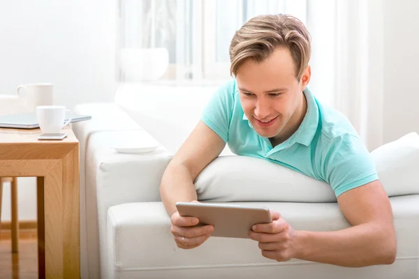 Homem com gadget sentado em casa — Fotografia de Stock