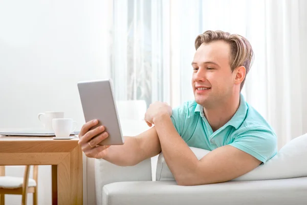 Hombre con gadget sentado en casa —  Fotos de Stock