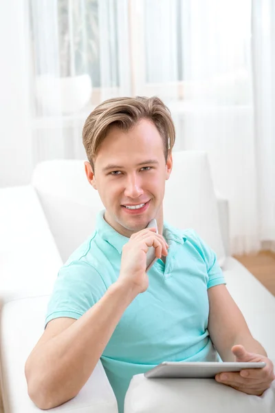 Man with gadget sitting at home — Stock Photo, Image