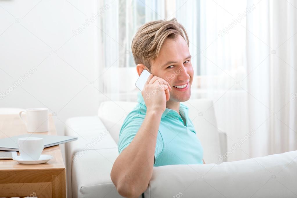 Man with gadget sitting at home