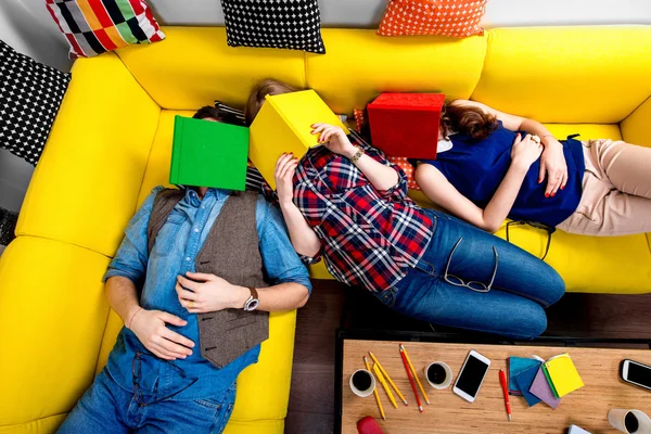 Спящие и уставшие студенты на диване — стоковое фото
