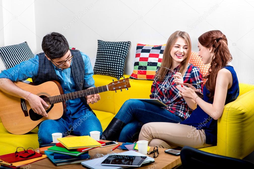 Man playing a guitar with girlfriends