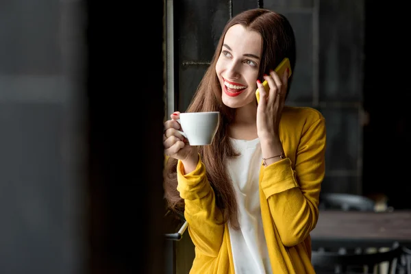 ผู้หญิงที่มีโทรศัพท์และถ้วยกาแฟ — ภาพถ่ายสต็อก