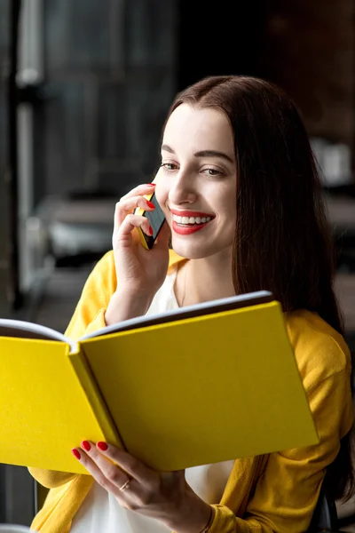 Mulher com livro e telefone celular — Fotografia de Stock