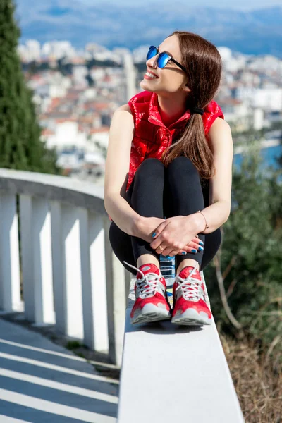 Mulher desportiva no beco do parque com vista para a cidade — Fotografia de Stock