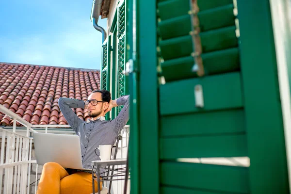 Man med laptop på balkongen — Stockfoto