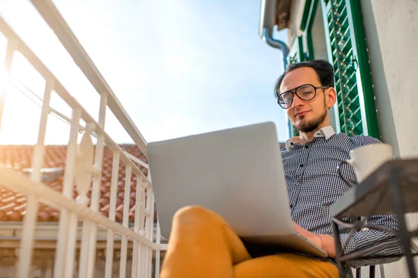 Mann mit Laptop auf dem Balkon — Stockfoto