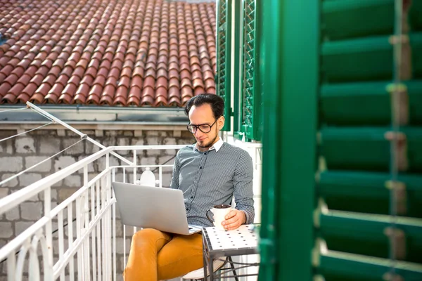 Homem com laptop na varanda — Fotografia de Stock