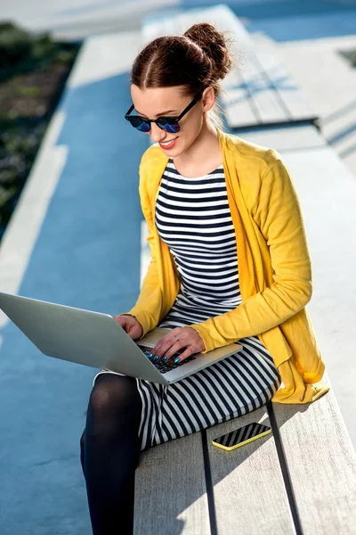 Wanita dengan laptop dan telepon di luar ruangan — Stok Foto