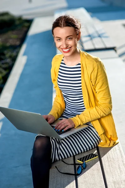 Femme avec ordinateur portable et téléphone à l'extérieur — Photo