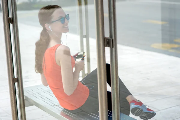 Mulher do esporte na estação de ônibus — Fotografia de Stock