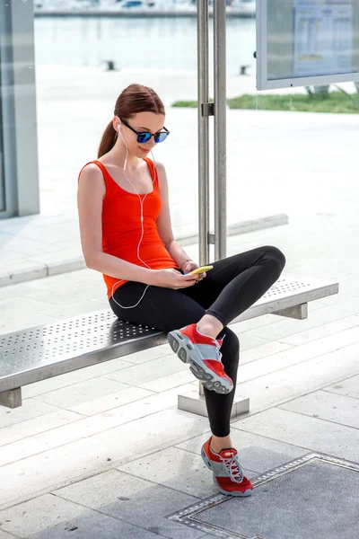 Sport woman at the bus station — Stock Photo, Image