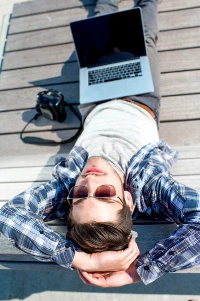 Joven fotógrafo con portátil y cámara fotográfica — Foto de Stock